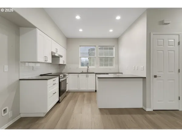 a kitchen with granite countertop white cabinets and white appliances