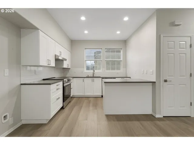 a kitchen with granite countertop white cabinets and white appliances