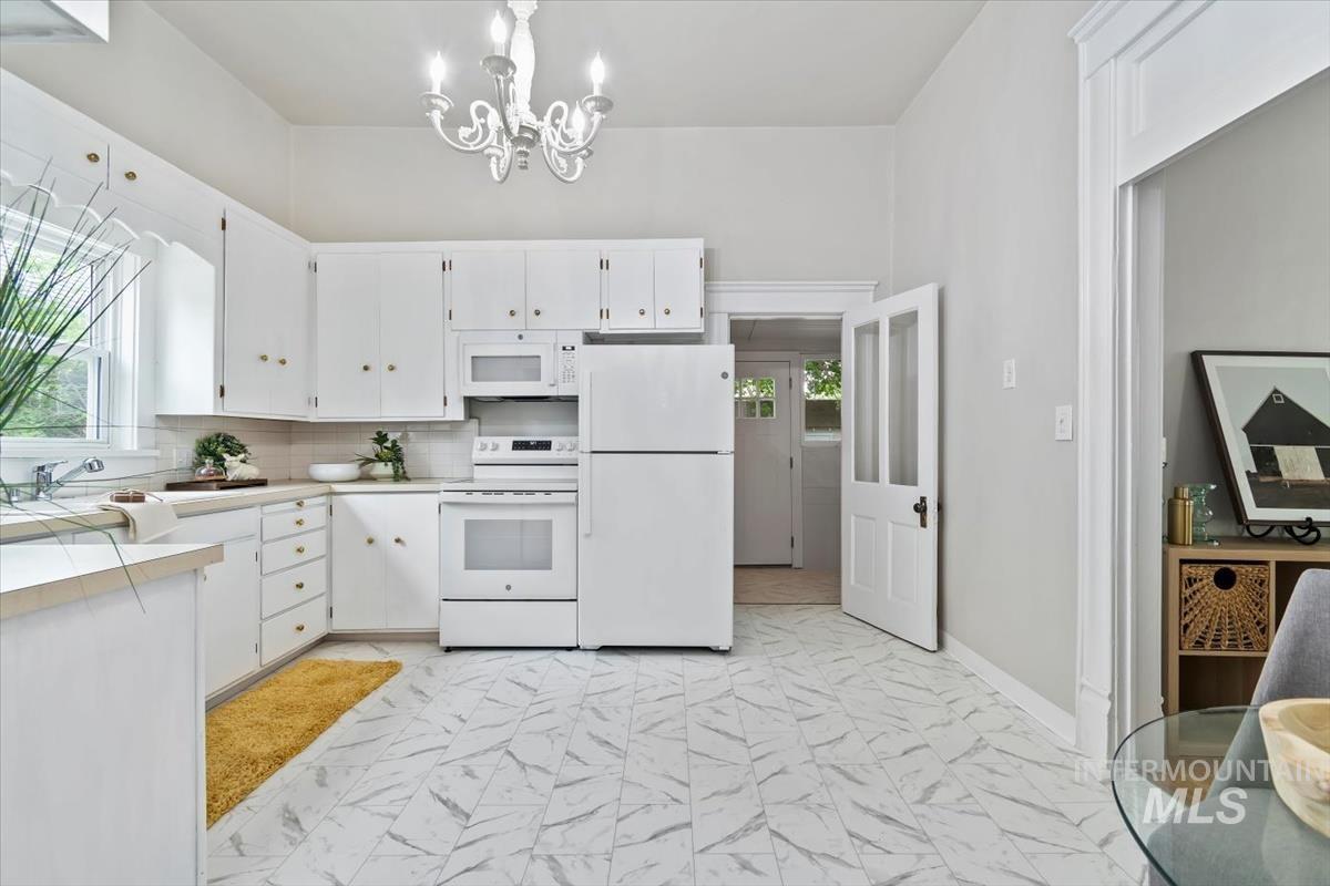 910 North 16th Street Boise, ID 83702 - Photo 22 of 47 Kitchen featuring white cabinetry with gold-toned hardware, white appliances, and a tile floor