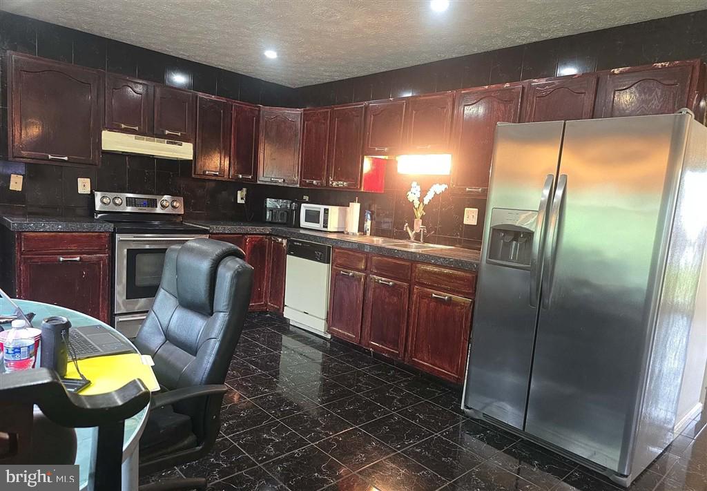 2448 Shellcove Court Waldorf, MD 20601 - Photo 11 of 18 a kitchen with stainless steel appliances granite countertop a sink refrigerator and cabinets