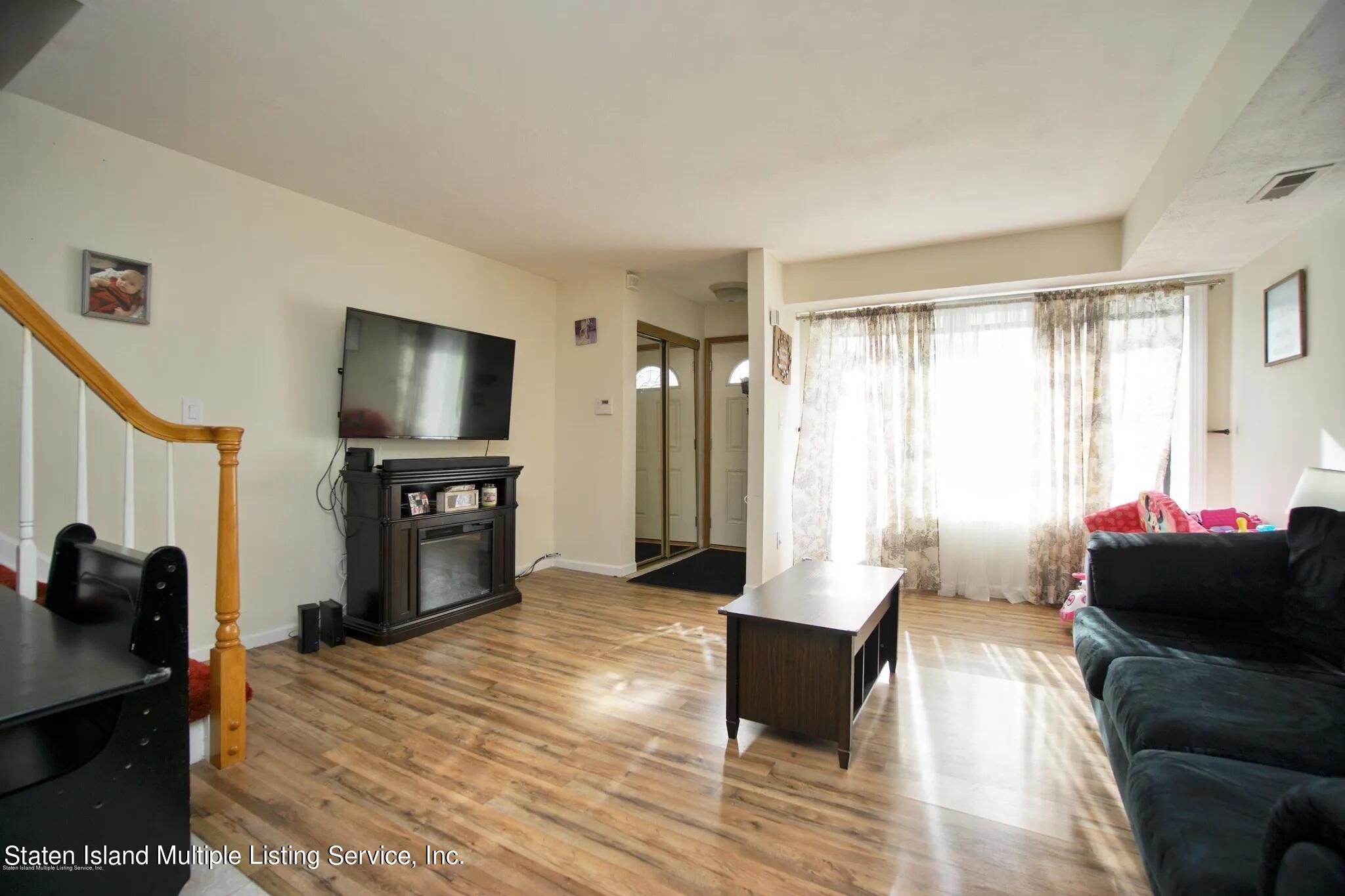 54 Selvin Loop Staten Island, NY 10303 - Photo 4 of 9 a living room with furniture and a flat screen tv
