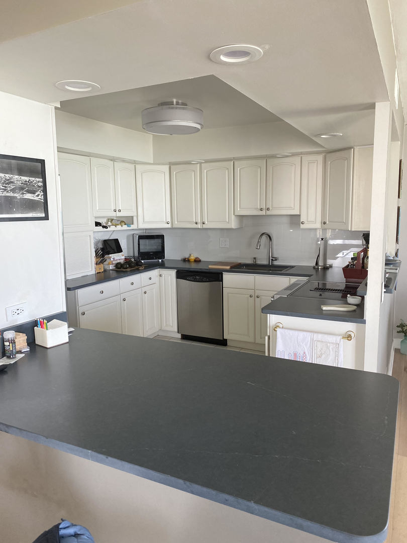 6007 North Sheridan Road, Unit 31A Chicago, IL 60660 - Photo 11 of 19 a kitchen with stainless steel appliances granite countertop a refrigerator a sink a stove and white cabinets