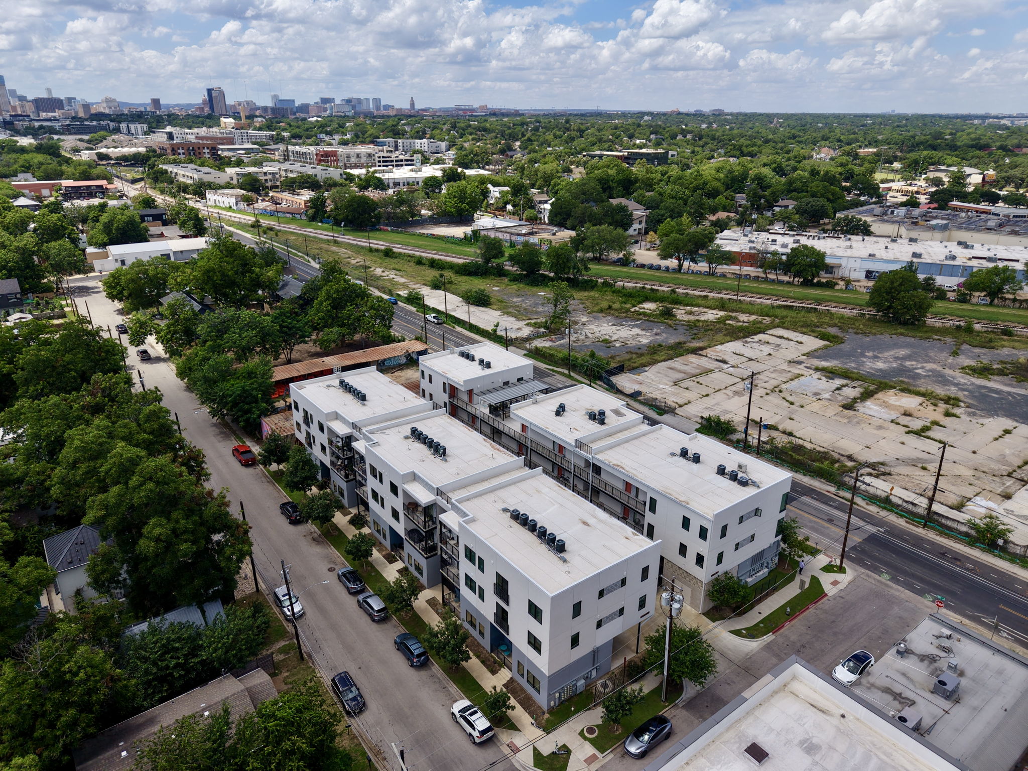 2709 East 5th Street, Unit 1306 Austin, TX 78702 - Photo 23 of 28 An aerial panorama reveals modern multi-story buildings nestled among established greenery with city views.