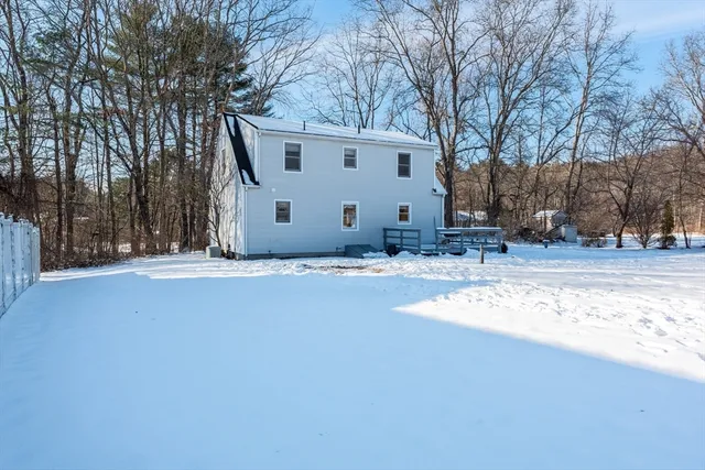 a view of a white house with a yard covered with snow