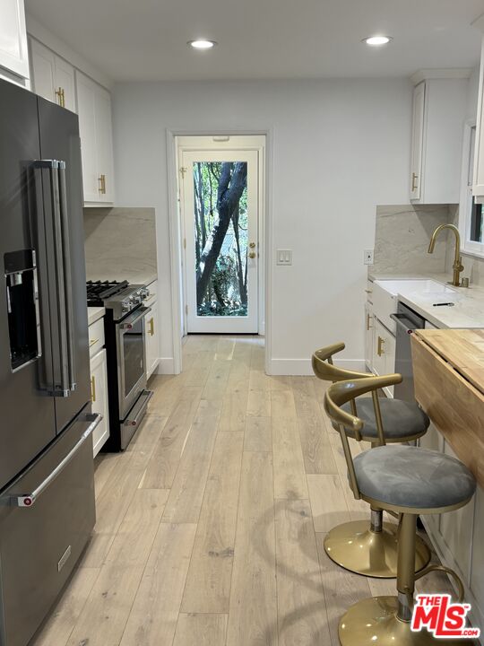 643 Hightree Road Santa Monica, CA 90402 - Photo 6 of 25 a kitchen with stainless steel appliances a stove a refrigerator and a sink