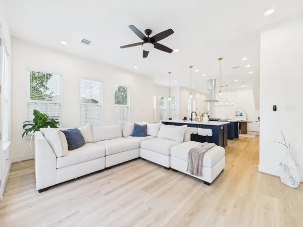 a living room with furniture kitchen view and a window