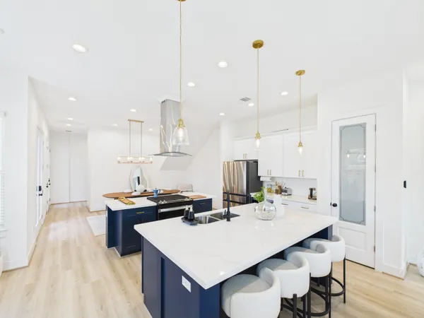 a kitchen with a sink a stove and chairs