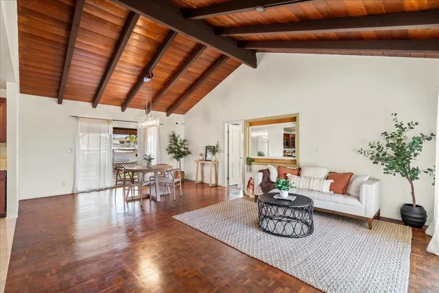 a living room with furniture wooden floor and a kitchen