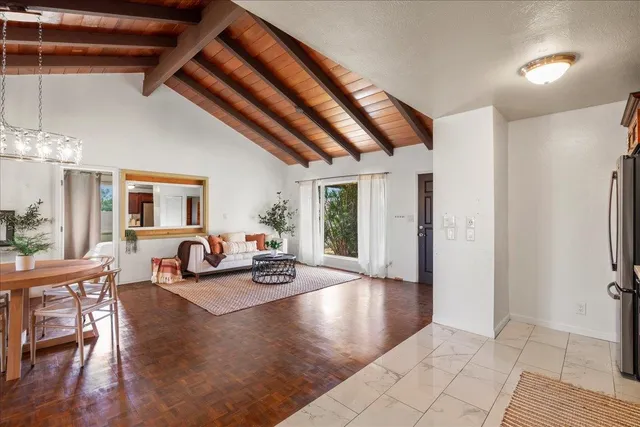 a kitchen with stainless steel appliances wooden floor dining table and chairs
