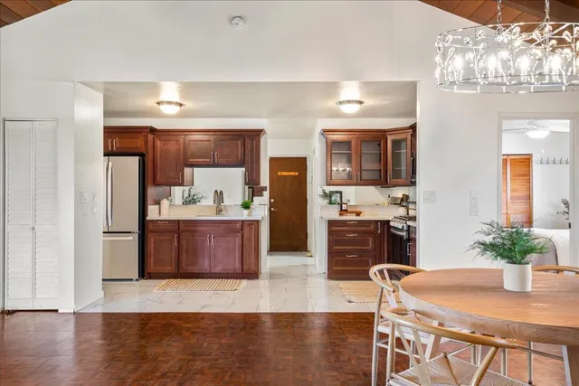 a kitchen with stainless steel appliances granite countertop a sink a stove and a wooden floors