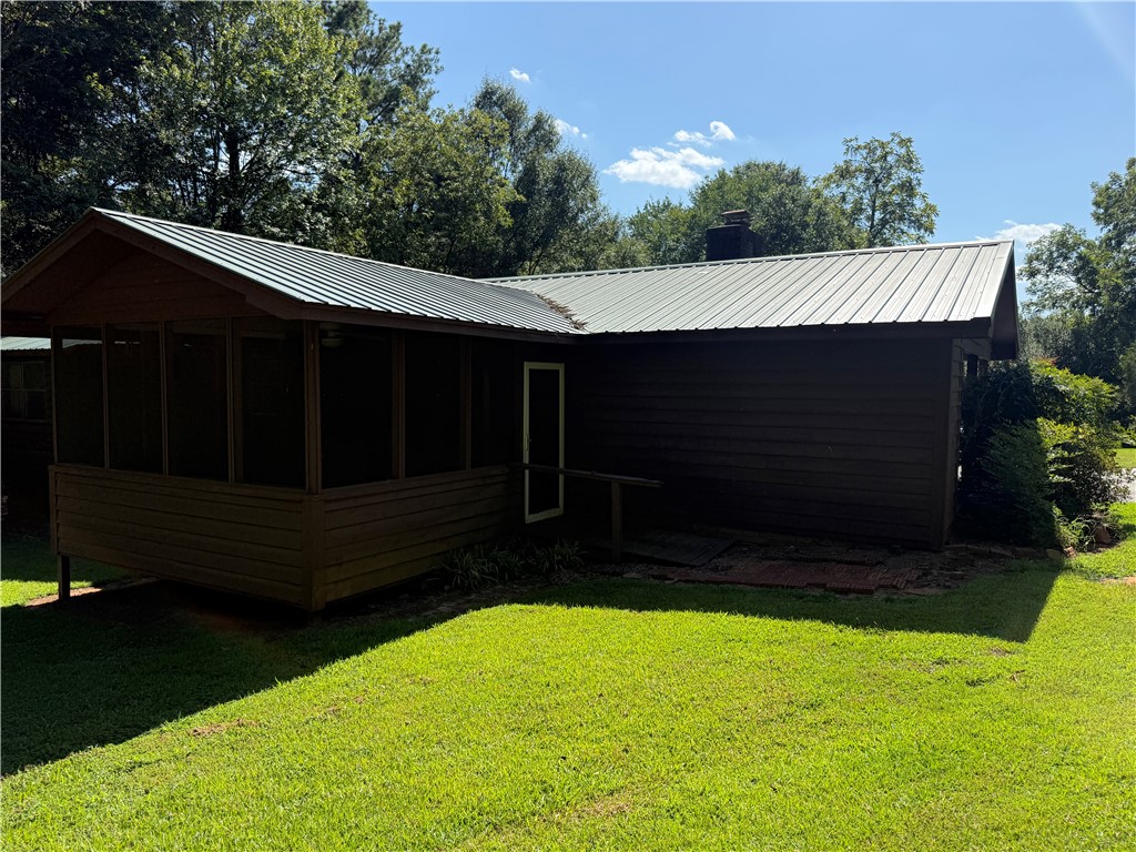 407 Seawright Drive Pendleton, SC 29670 - Photo 3 of 29 A metal roof and rustic wood siding blend with the serene natural landscape.