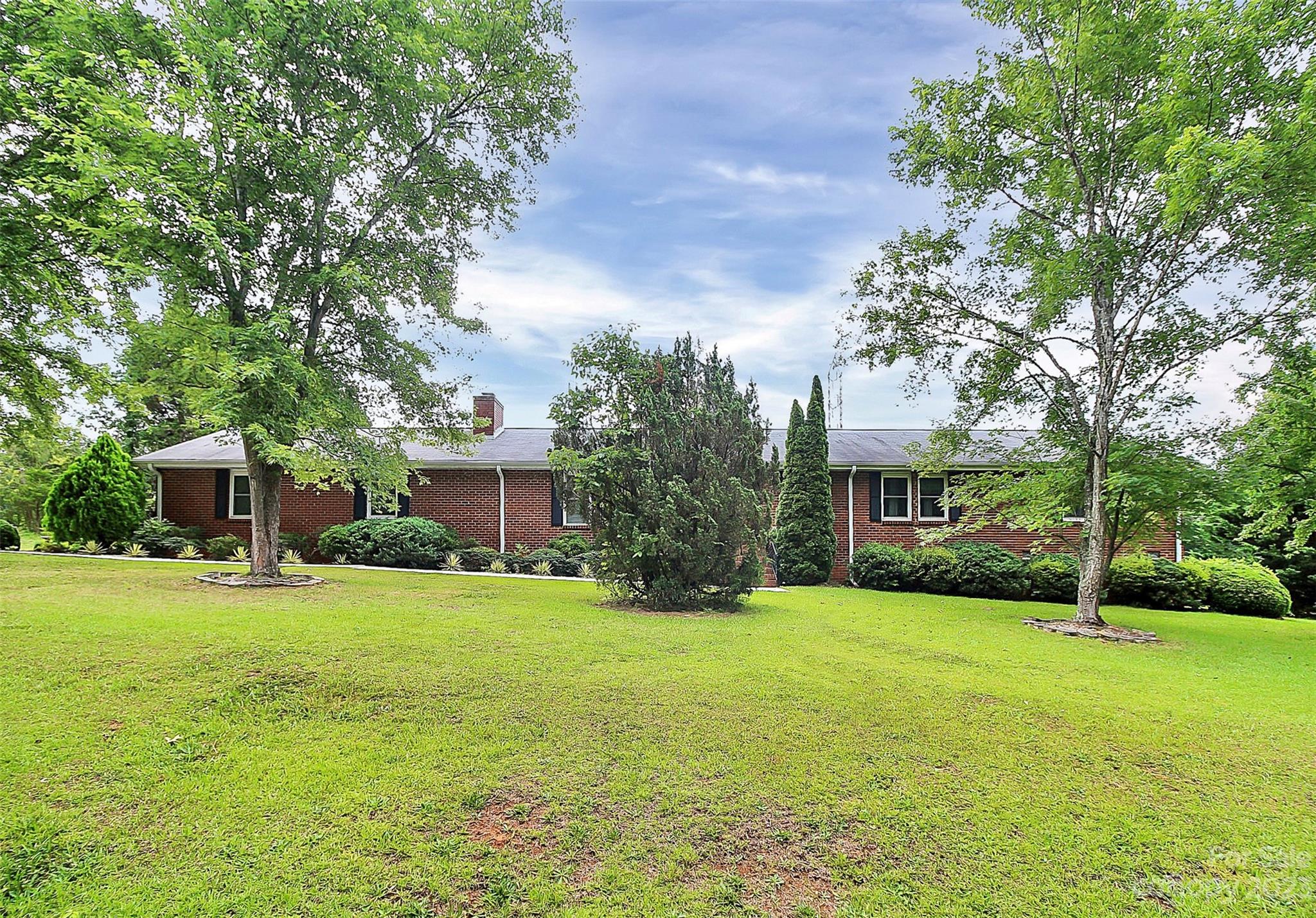 870 Bridle Path Fort Mill, SC 29708 - Photo 2 of 34 a brick house with a yard plants and large trees