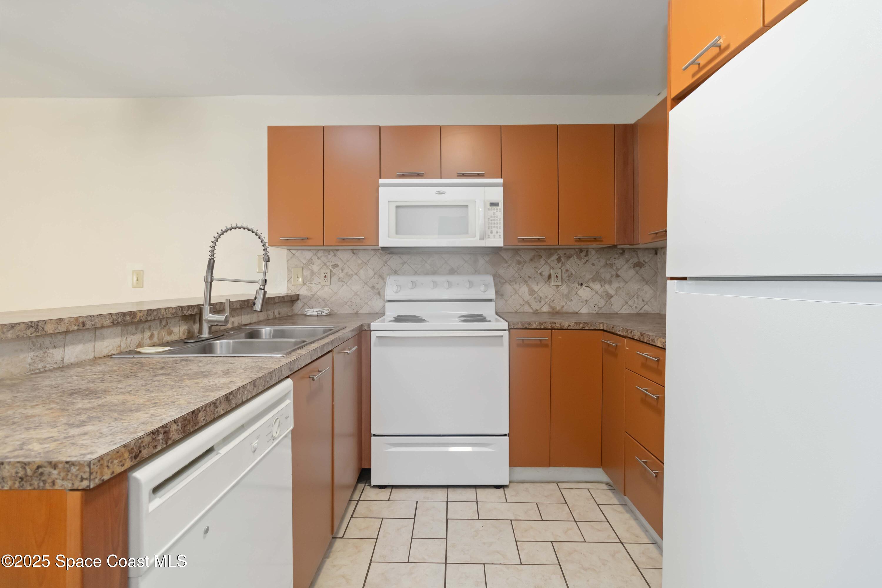 1480 Sheafe Avenue Northeast, Unit 103 Palm Bay, FL 32905 - Photo 17 of 31 a kitchen with a sink stove and cabinets