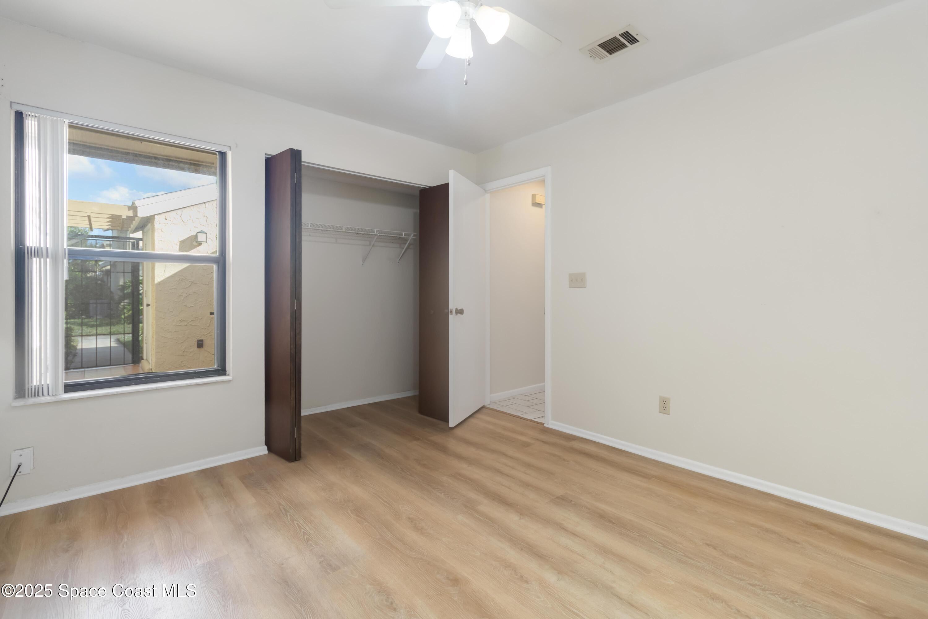 1480 Sheafe Avenue Northeast, Unit 103 Palm Bay, FL 32905 - Photo 23 of 31 an empty room with a window and wooden floor