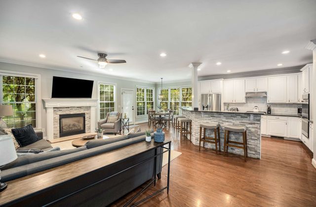 a living room with stainless steel appliances kitchen island furniture and a fireplace