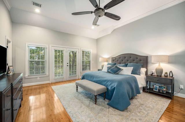 a bedroom with a large bed and a flat tv screen