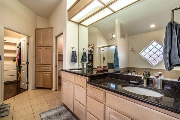 a bathroom with a double vanity sink a mirror and a shower