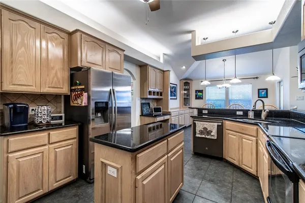 a kitchen with stainless steel appliances granite countertop a stove refrigerator sink and cabinets