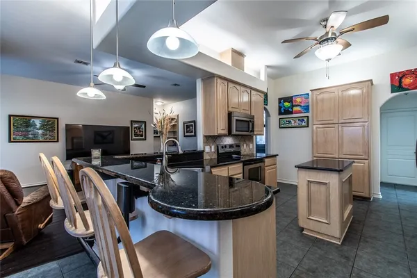 a kitchen with stainless steel appliances granite countertop a sink a stove and a refrigerator