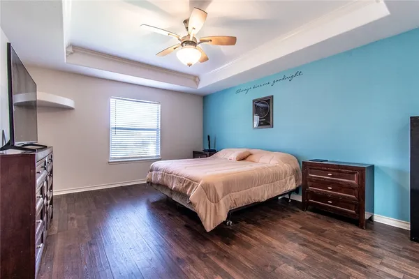 a bedroom with a large bed and a ceiling fan