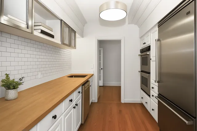 a kitchen with cabinets and wooden floor