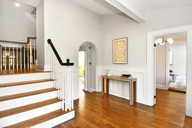 a view of a hallway with wooden floor and a living room