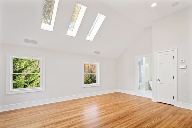 a view of empty room with window and wooden floor