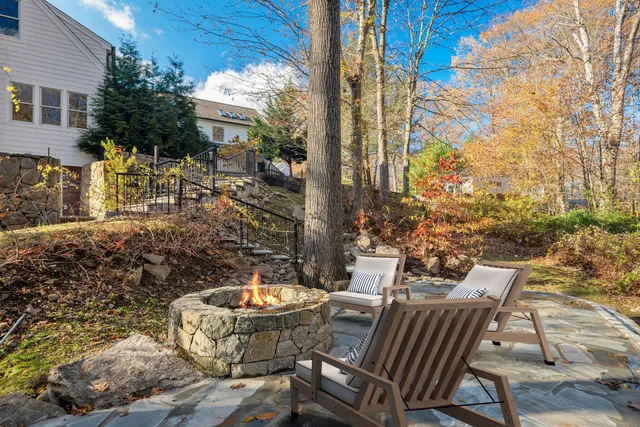 a view of a patio with table and chairs potted plants and large tree