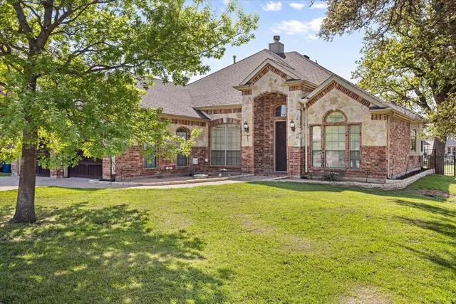 a front view of a house with yard and tree