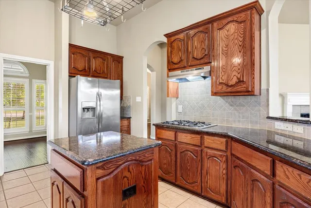 a kitchen with stainless steel appliances granite countertop a sink and a refrigerator