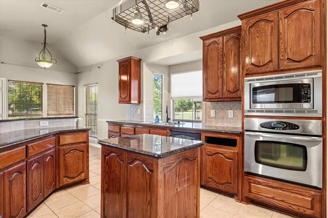 a kitchen with stainless steel appliances granite countertop a stove microwave and cabinets
