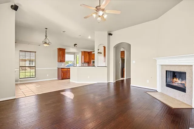 an empty room with wooden floor fireplace and windows