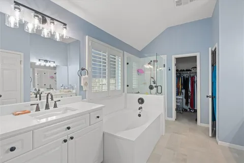 a bathroom with a tub sink and mirror