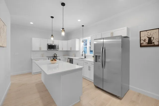 a kitchen with kitchen island a sink stainless steel appliances and cabinets