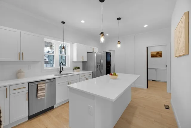 a large kitchen with kitchen island a sink a center island a stove a refrigerator and a counter top space