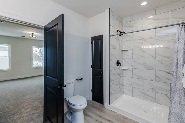 a bathroom with a shower a toilet and a shower