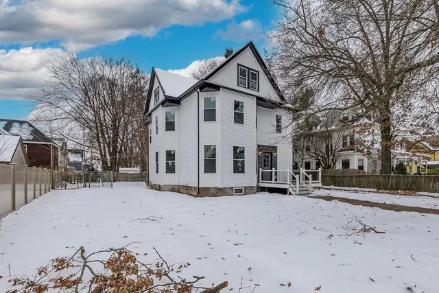 a view of a white house with a snow in the yard