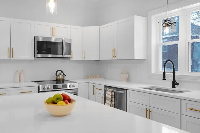 a kitchen with a sink a microwave and cabinets