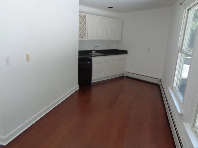 an empty room with wooden floor and a fireplace