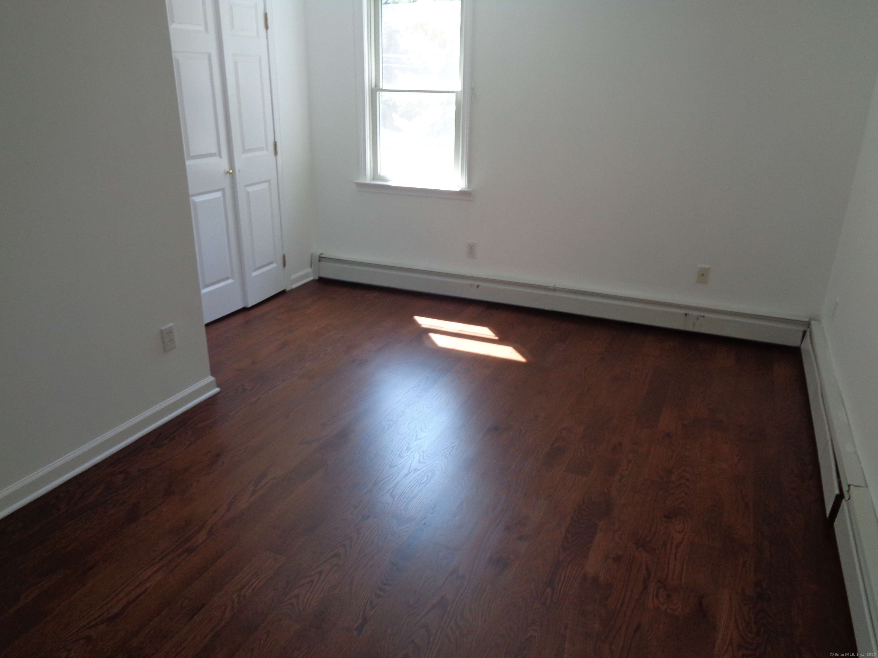 531 Hollow Tree Ridge Road Darien, CT 06820 - Photo 19 of 37 an empty room with wooden floor and windows