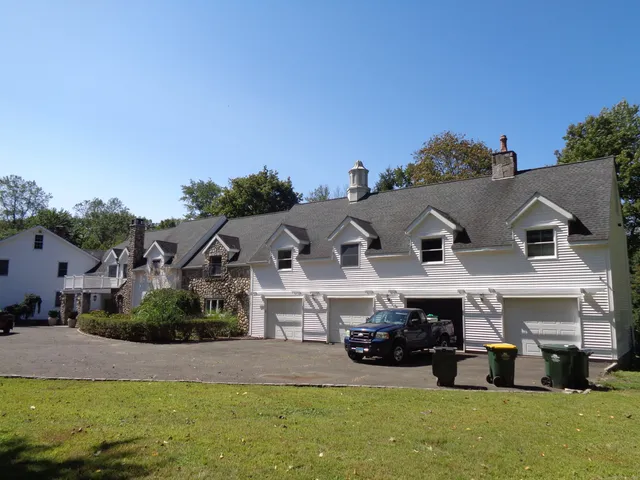 a view of a big house with a big yard and large trees