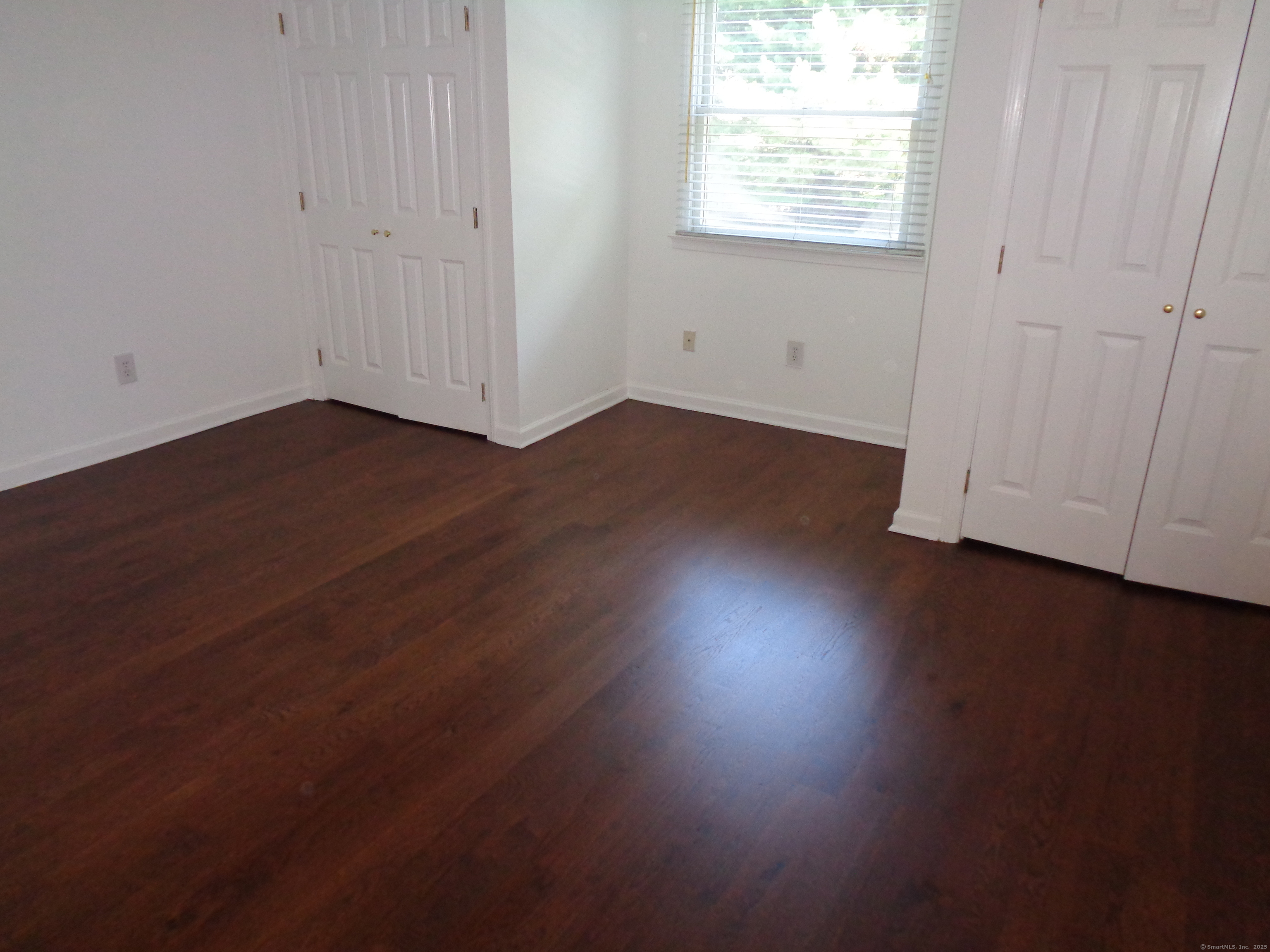 531 Hollow Tree Ridge Road Darien, CT 06820 - Photo 24 of 37 an empty room with wooden floor and windows