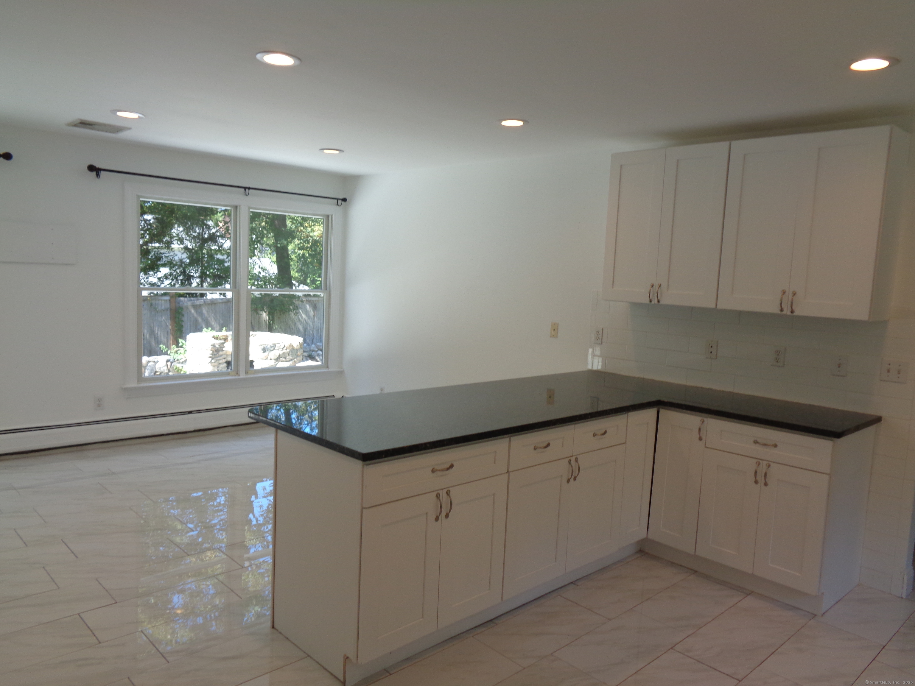 531 Hollow Tree Ridge Road Darien, CT 06820 - Photo 10 of 37 a kitchen with granite countertop white cabinets and a window