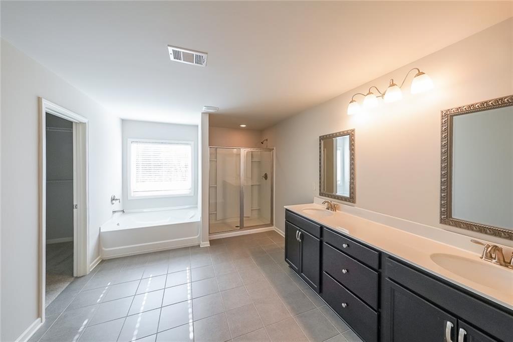 408 After Glow Summit Canton, GA 30114 - Photo 33 of 52 a spacious bathroom with a granite countertop sink a mirror and a shower