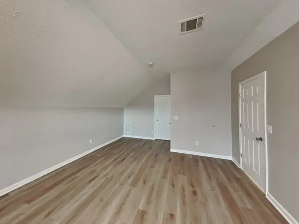 a view of a room with wooden floor