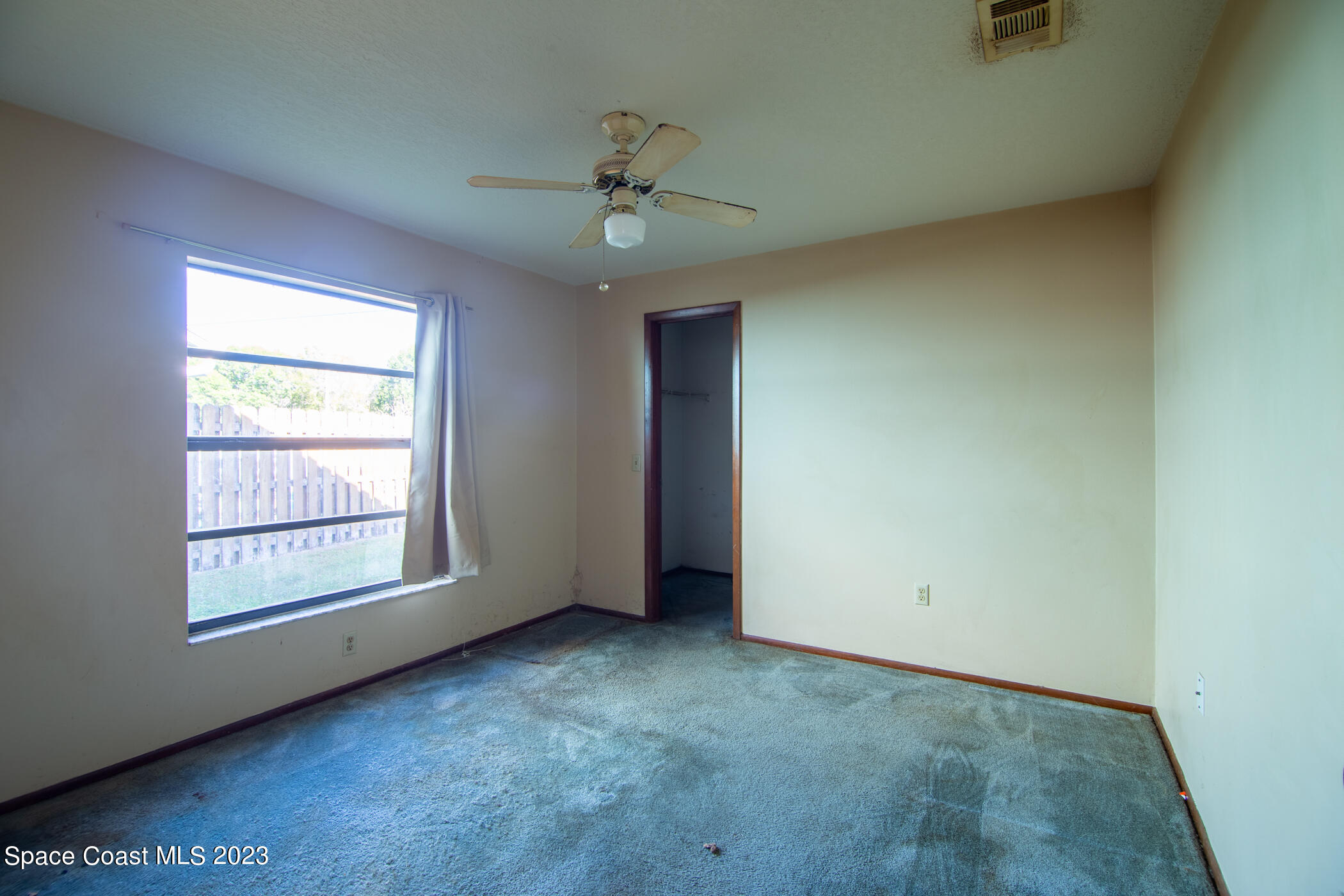 1816 Clover Circle Melbourne, FL 32935 - Photo 11 of 13 an empty room with a window and ceiling fan