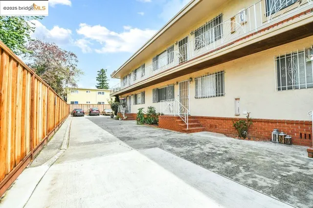 a front view of a house with large trees