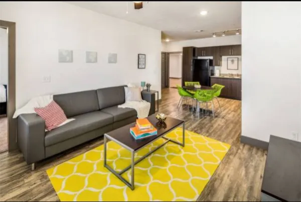 a living room with furniture and a wooden floor