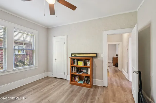 a view of an empty room with window and wooden floor