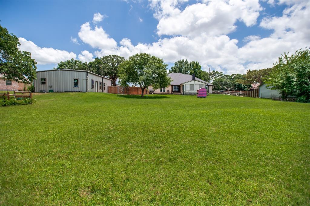 5643 West Caylor Road Fort Worth, TX 76244 - Photo 32 of 37 Expansive green lawn with mature trees and a metal-sided outbuilding